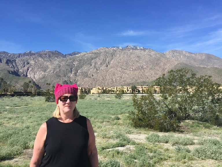 the author sporting hand-knit pussyhat with mountain backdrop.  